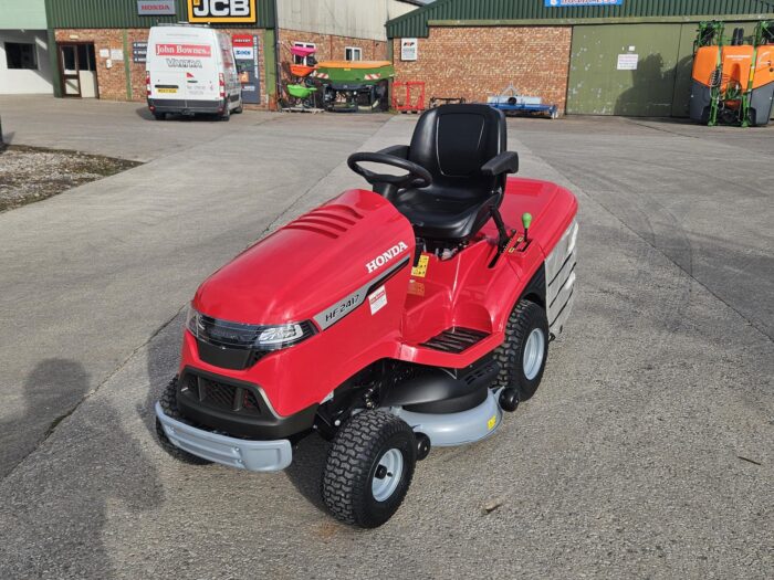 Honda HF2417HME ride-on lawn tractor with red body, black seat, and large rear grass collector, designed for high-performance garden mowing.